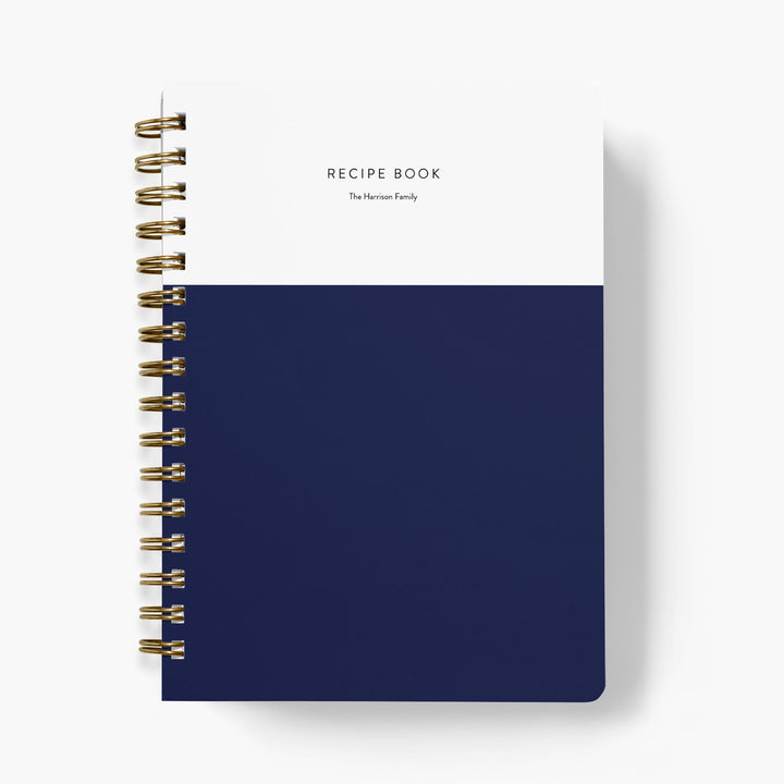 Custom colorblock recipe book with white top half and navy bottom half on a white background