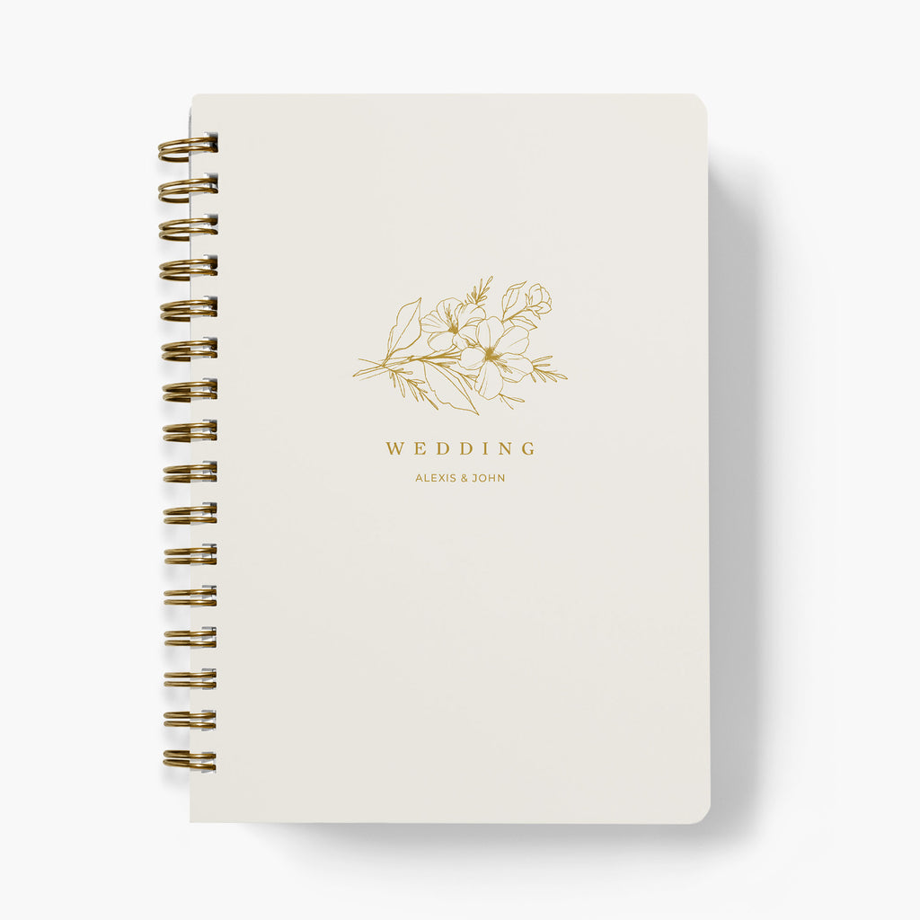 Custom sprig bouquet wedding planner with creme cover and gold floral design and 'Wedding' text on a white background