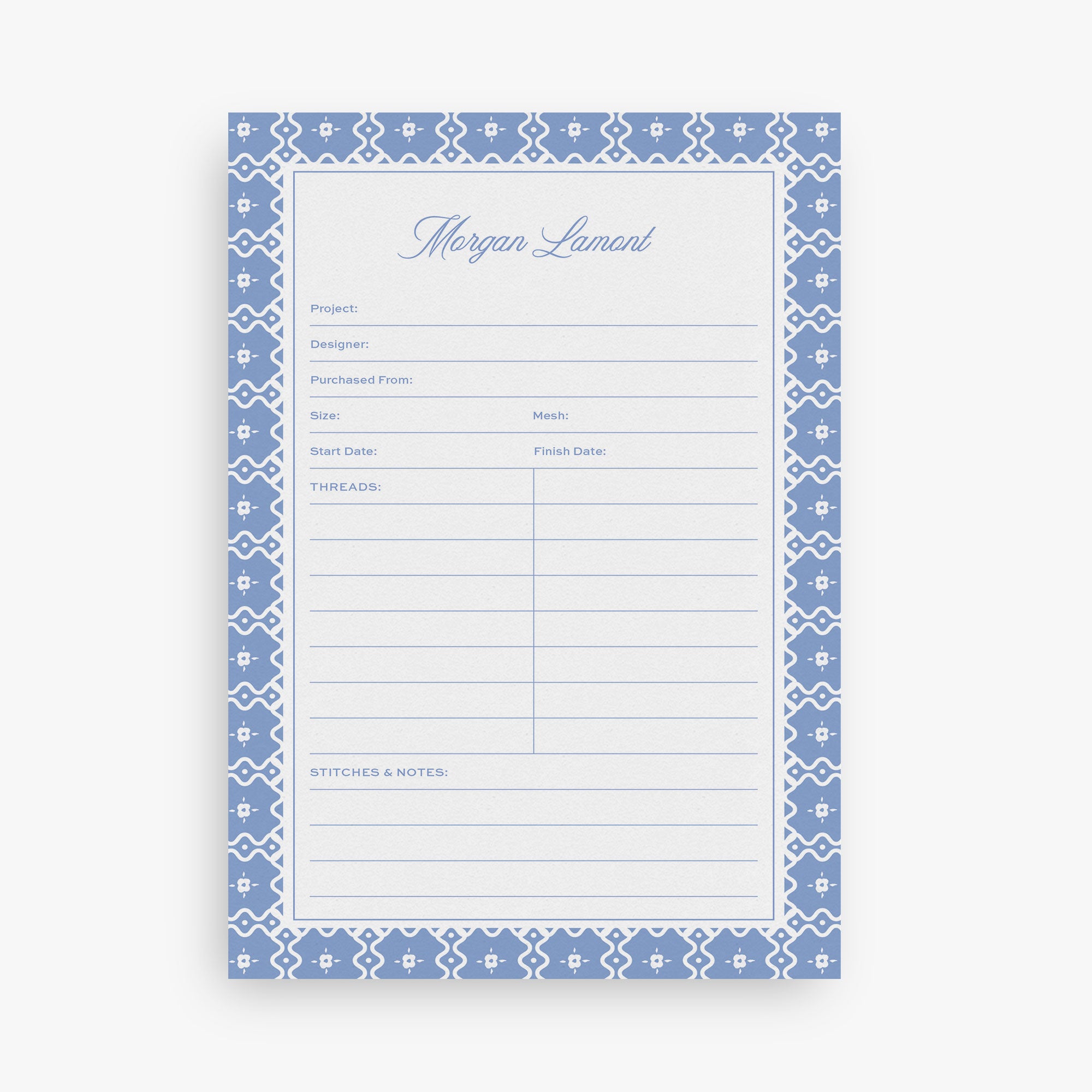 Custom needlepoint project notepad with blue decorative border and text on a white background
