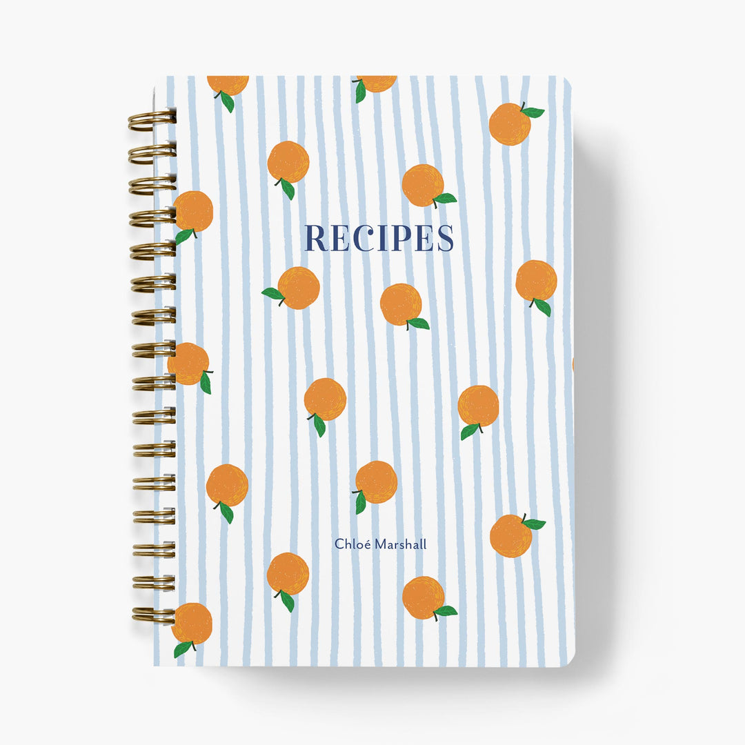 Custom recipe journal in a blue and white stripe with cute orange pattern on a white background.