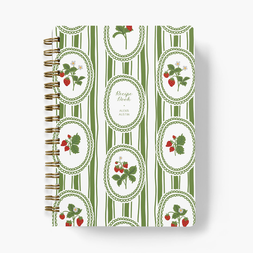 Custom recipe book with green and white striped cover featuring strawberry illustrations on a white background