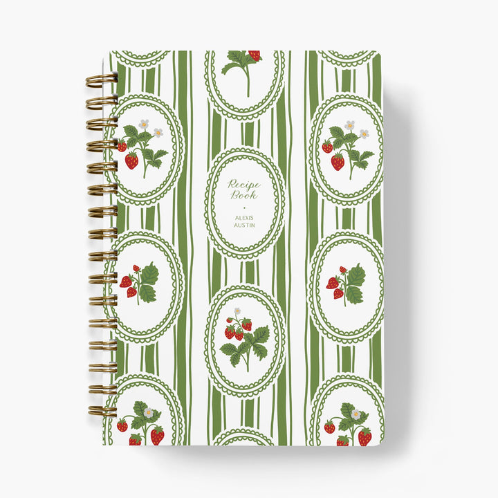 Custom recipe book with green and white striped cover featuring strawberry illustrations on a white background