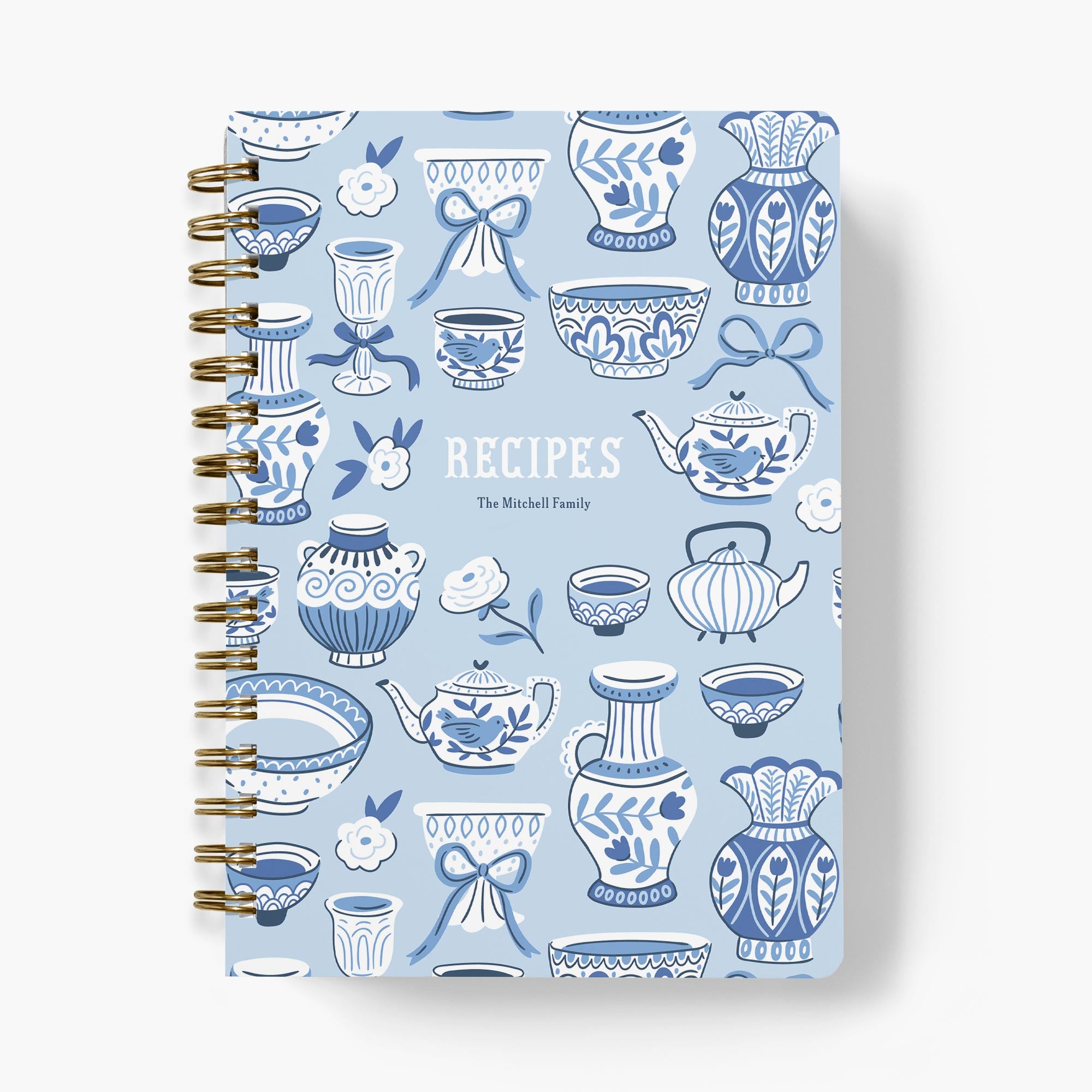 Custom recipe book with a chinoiserie-style pattern of blue and white teapots and teacups on a white background.