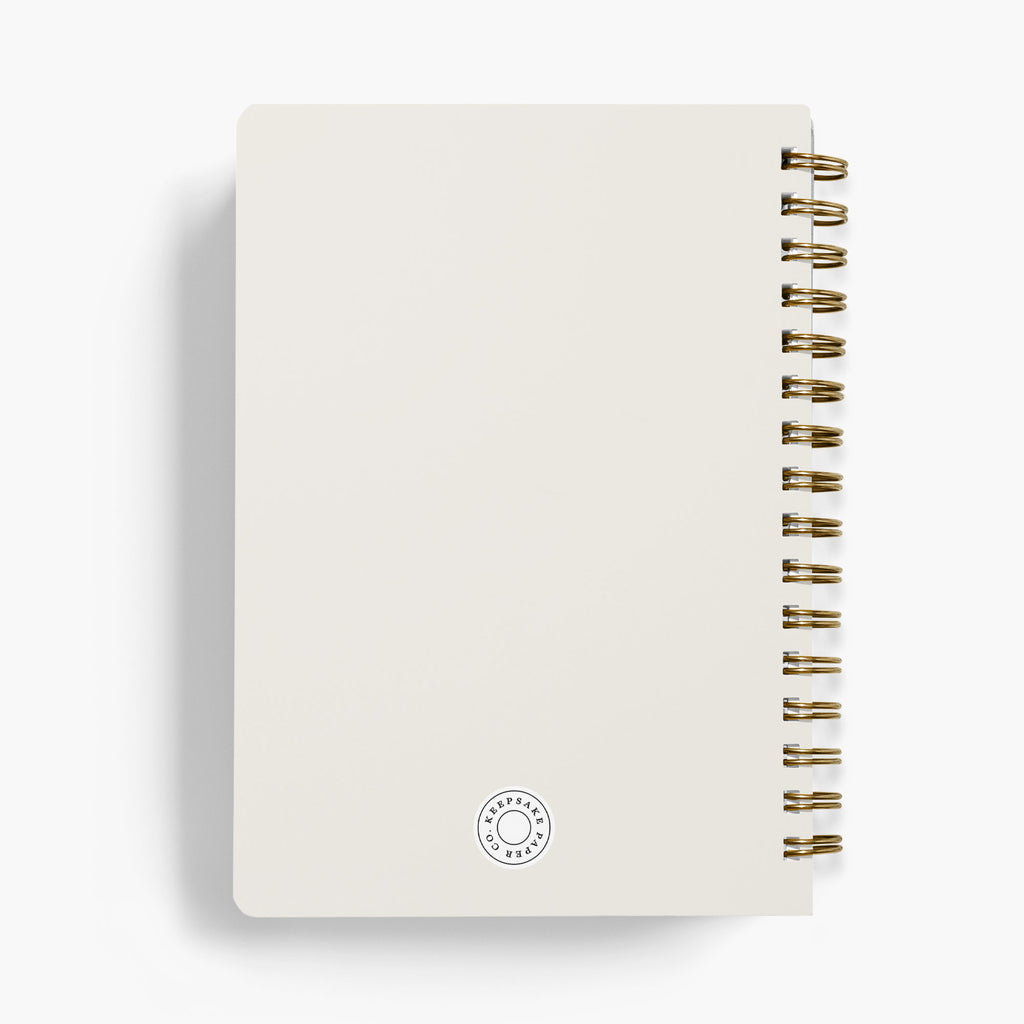Back view of a personalized wedding planner with gold spiral binding on a white background