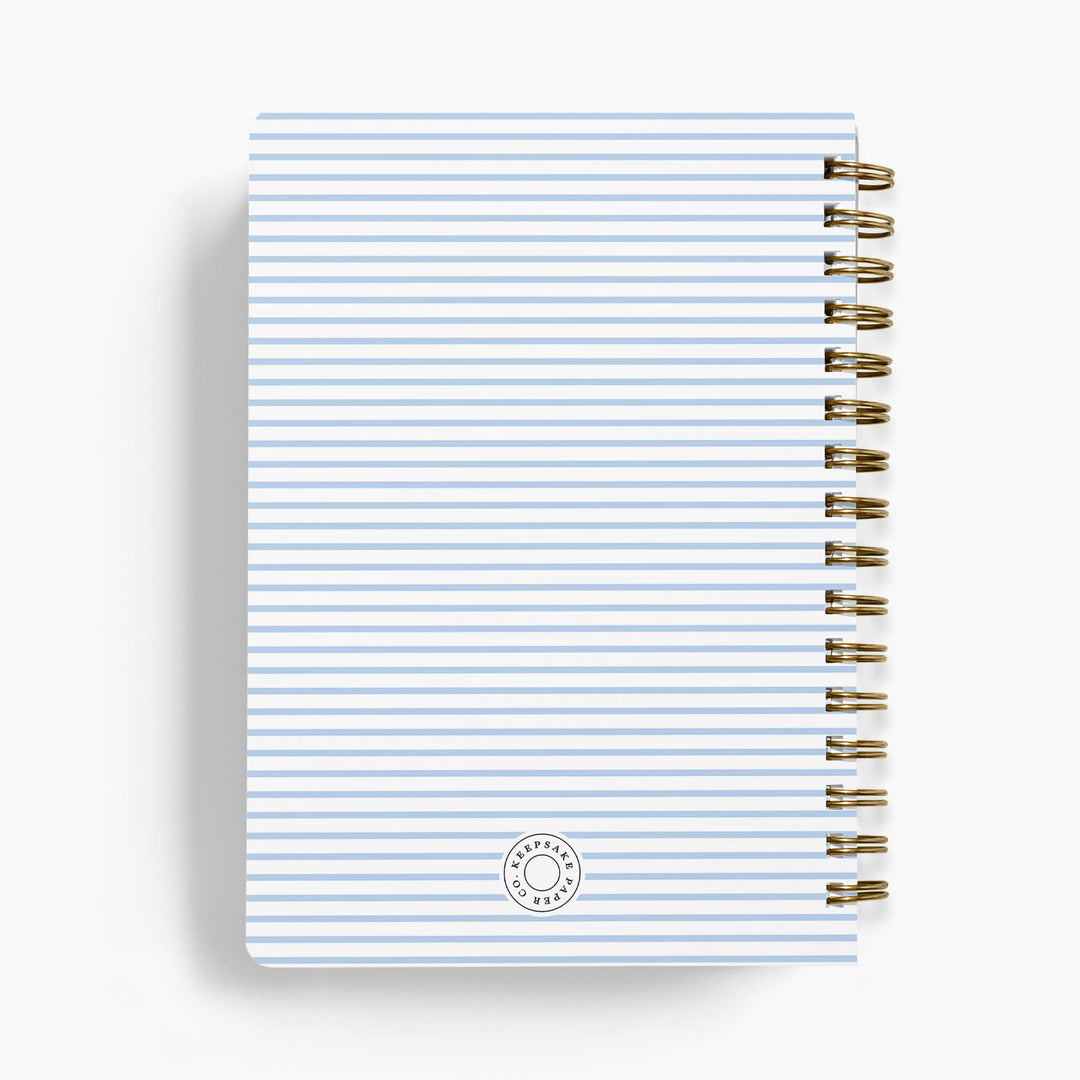 Personalized recipe notebook with striped cover and gold spiral binding on a white background
