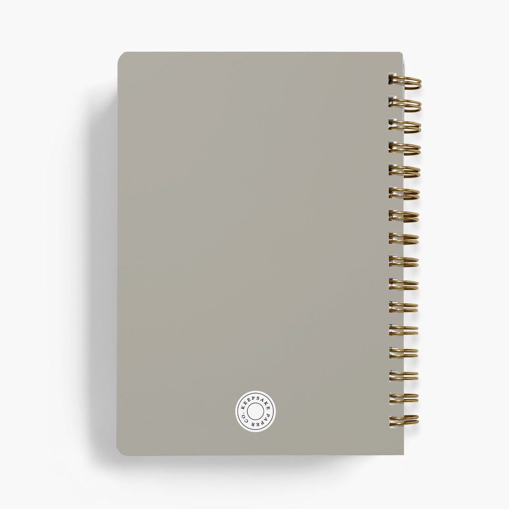 Back view of a personalized LGBT wedding planner with gold spiral binding on a white background
