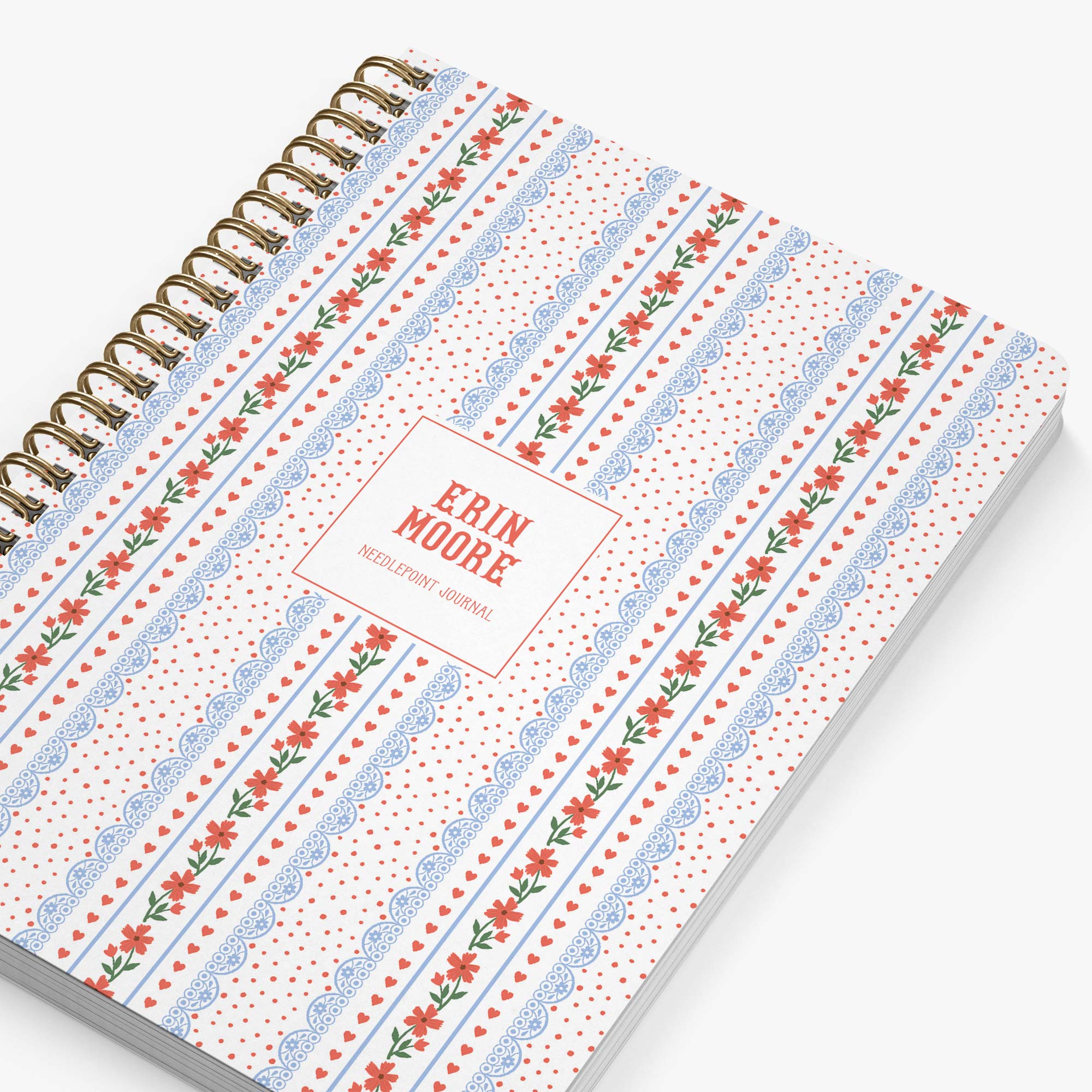 Personalized needlepoint journal with floral pattern in red, white and blue on a white background