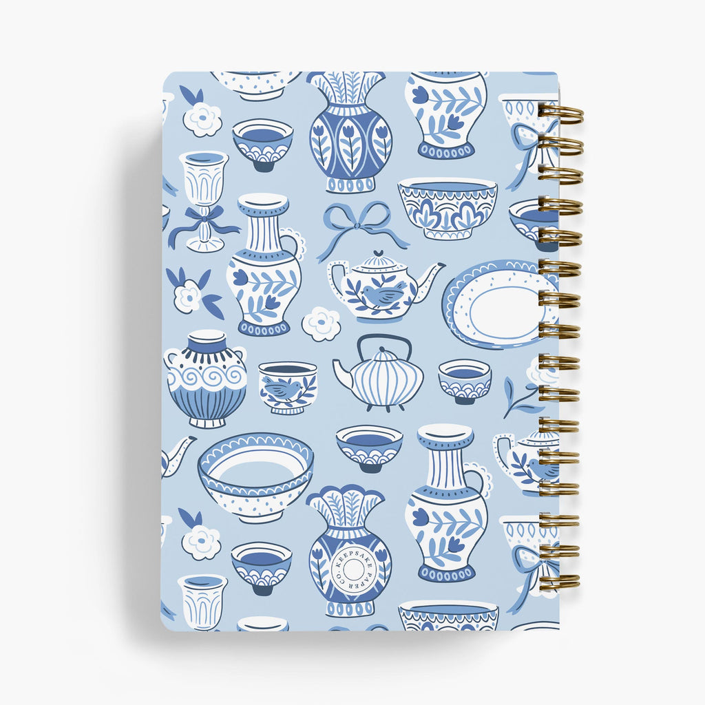 Back view of a recipe book with chinoiserie teapots and teacups in blue and white on a white background.