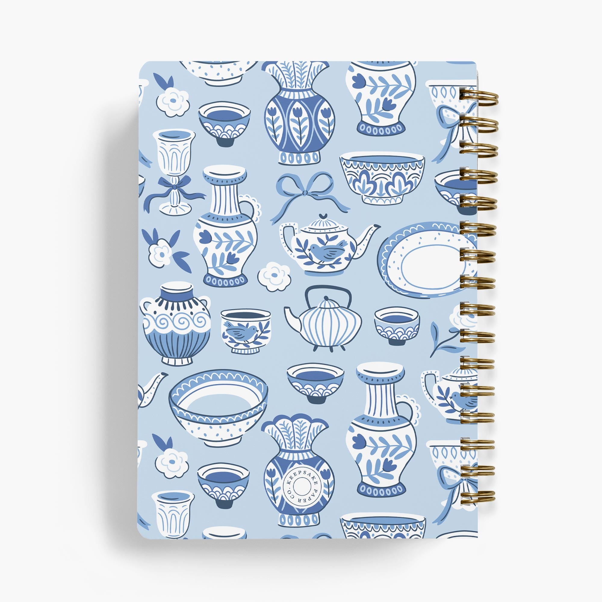 Back view of a recipe book with chinoiserie teapots and teacups in blue and white on a white background.