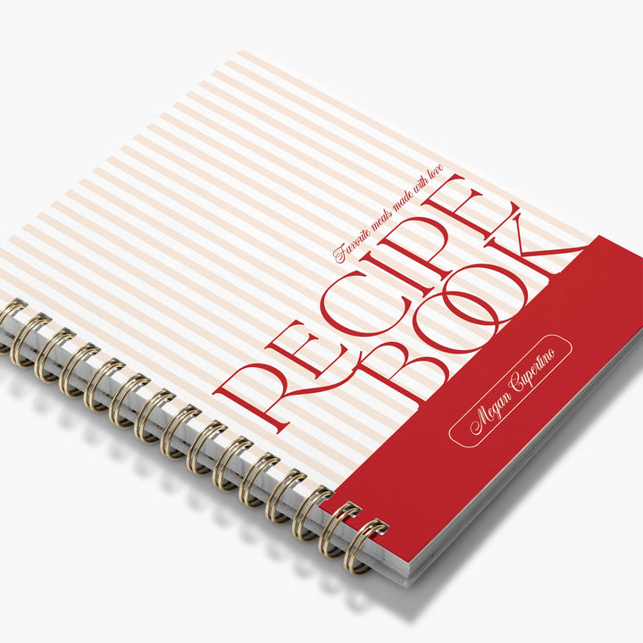 Custom cookbook in a pink and red stripe design with bold text and brass binding