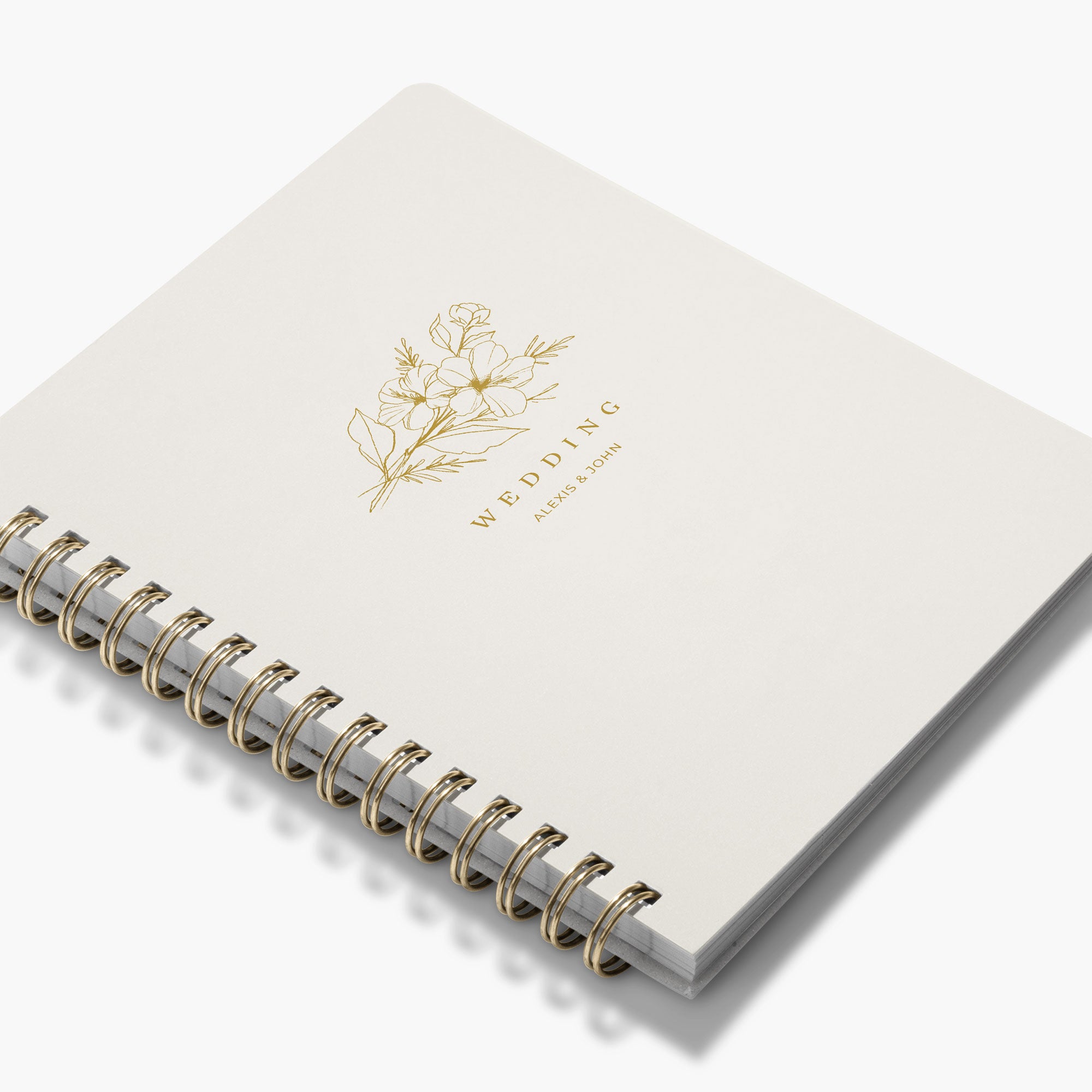 Angled view of a custom wedding book with gold floral design and text on a white background