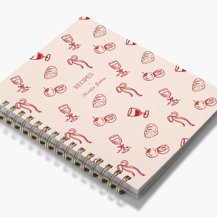 Custom cookbook with a red and pink food pattern in a cute doodle style, bound with gold wire.