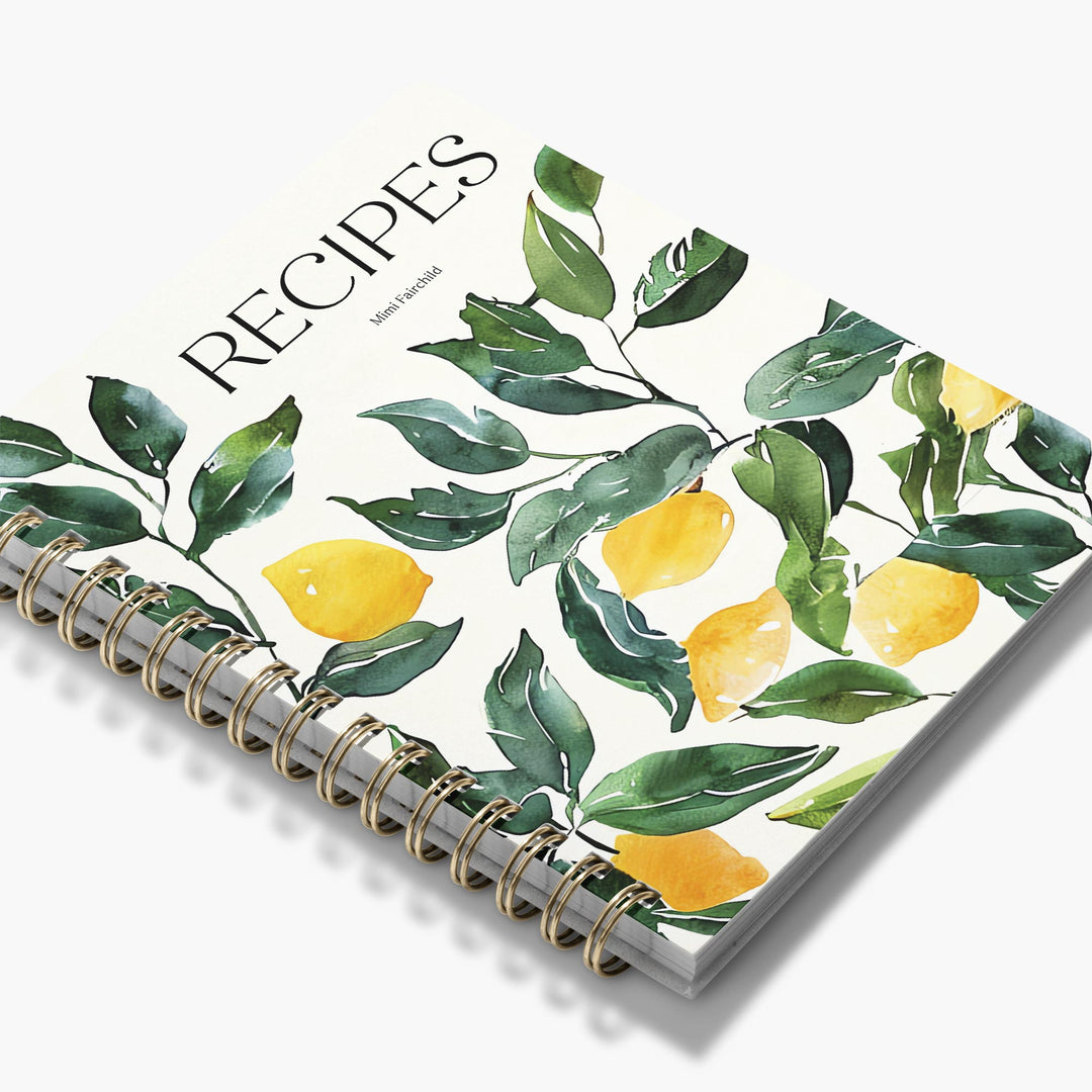 Spiral-bound custom cookbook with lemon and leaf design on a white background