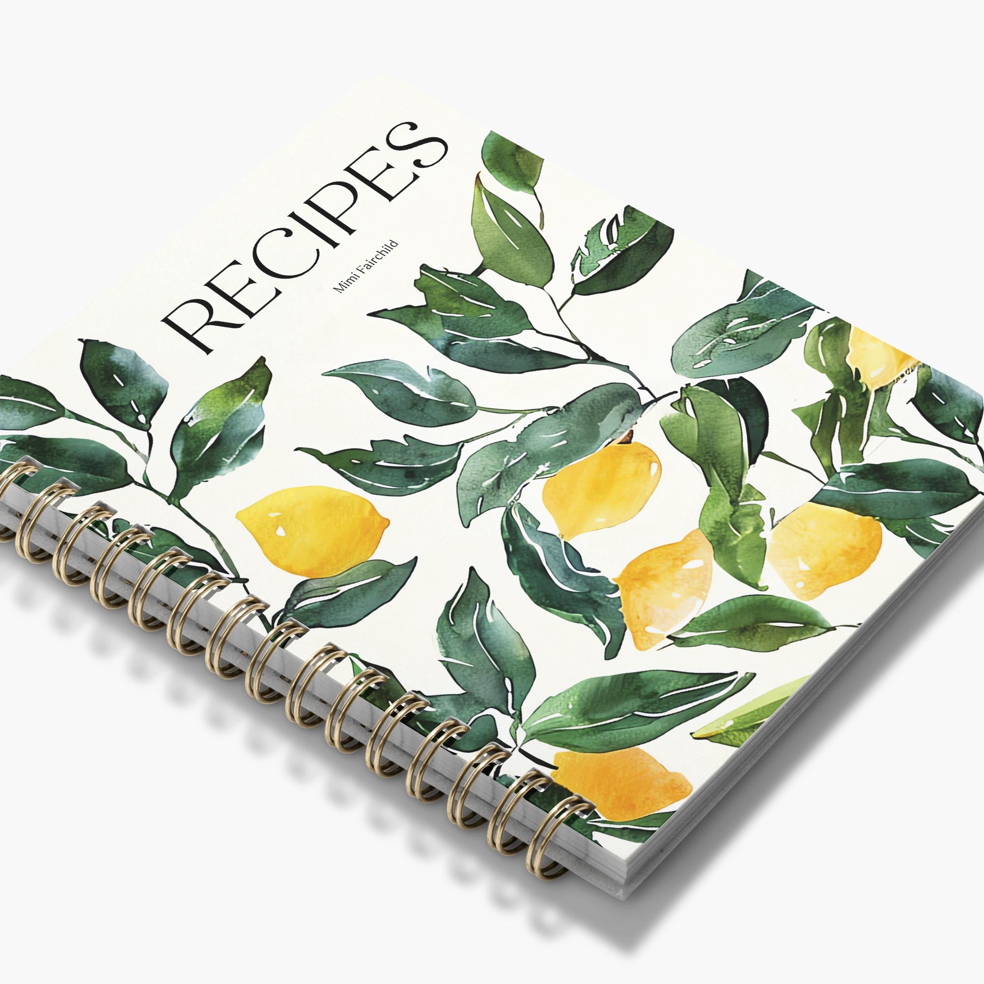 Spiral-bound custom cookbook with lemon and leaf design on a white background
