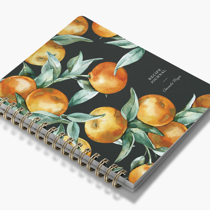 Custom cookbook with a watercolor botanical design of oranges and leaves bound in brass wire binding