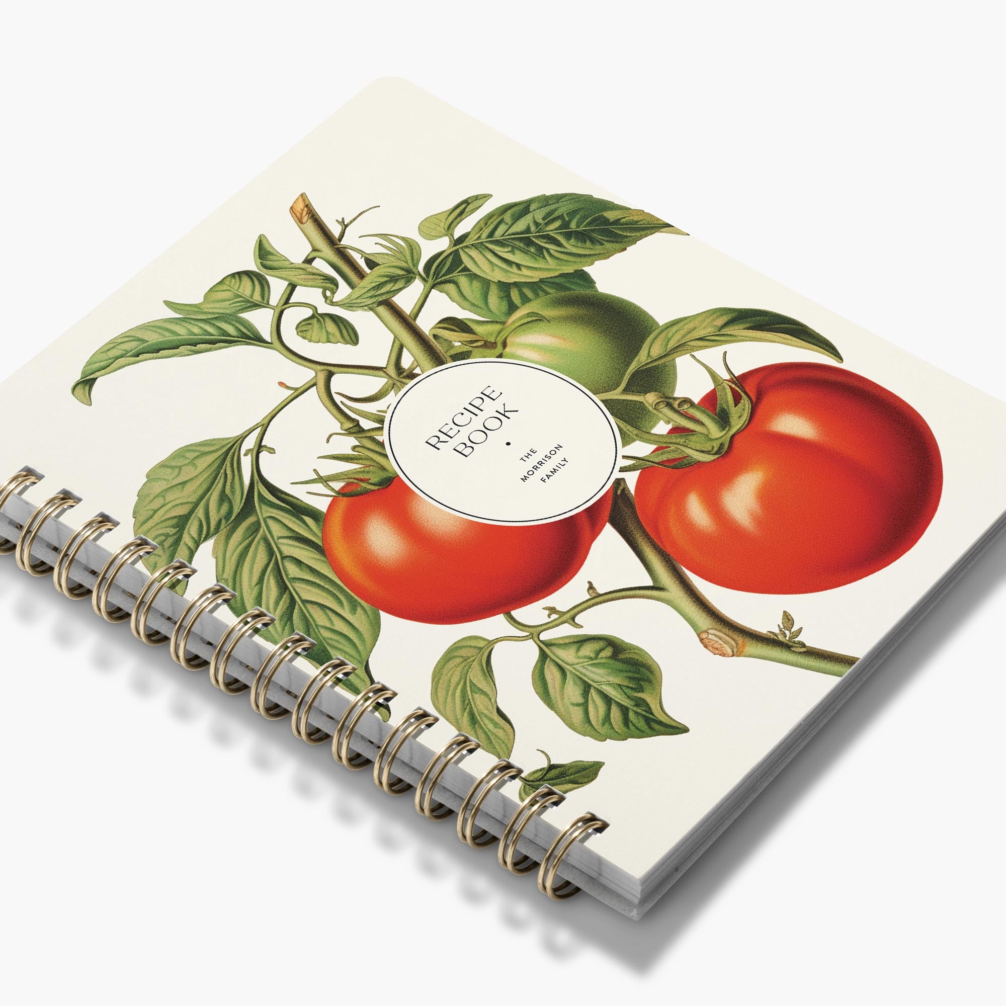 Spiral-bound custom cookbook with botanic red and green tomato illustration on an ivory background
