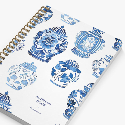 Address book with blue floral and decorative urn designs on a white background