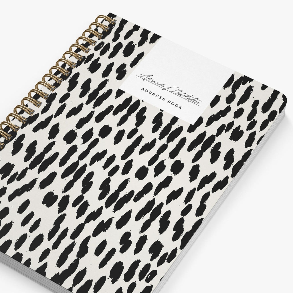 Address book with black and white leopard print cover on a white background