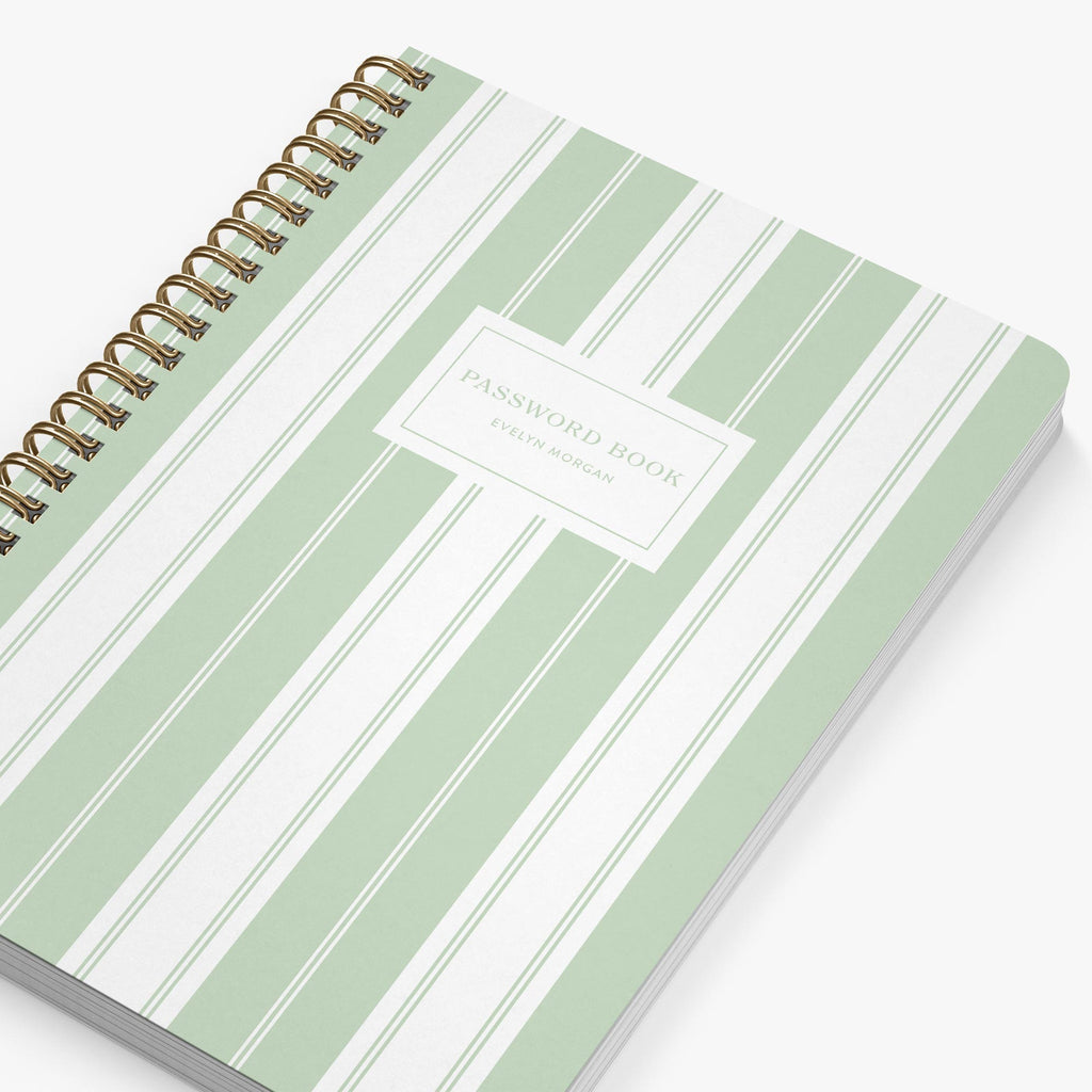 Green and white striped password book with gold spiral binding on a white background