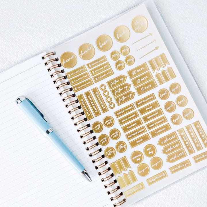 Sheet of gold foil planning stickers included with wedding planner for customizing checklists, timelines, and important reminders