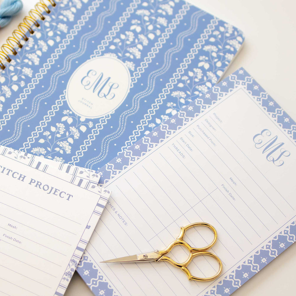 Personalized needlepoint products including a stitch journal, project notepad and stitch project cards styled with gold embroidery scissors