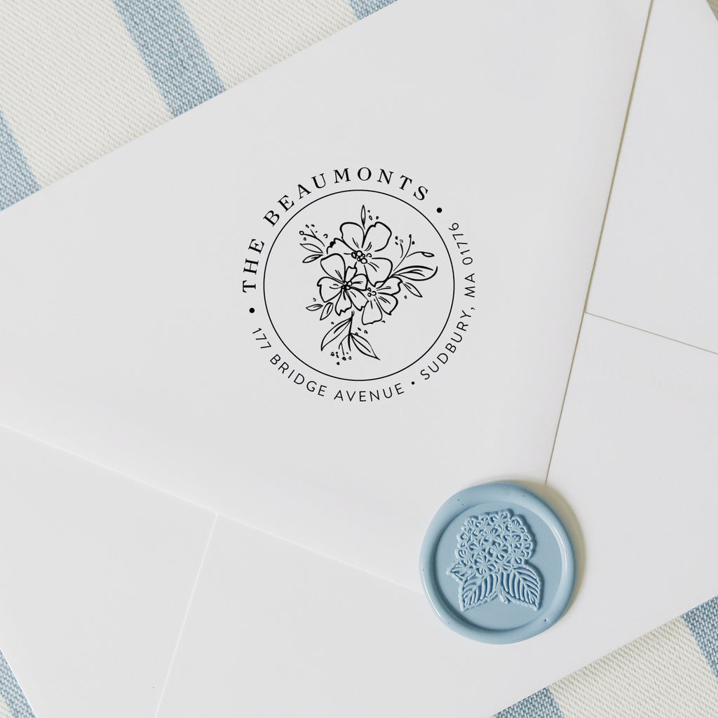 Personalized return address stamp in a wildflower design on a white envelope with hydrangea wax seal