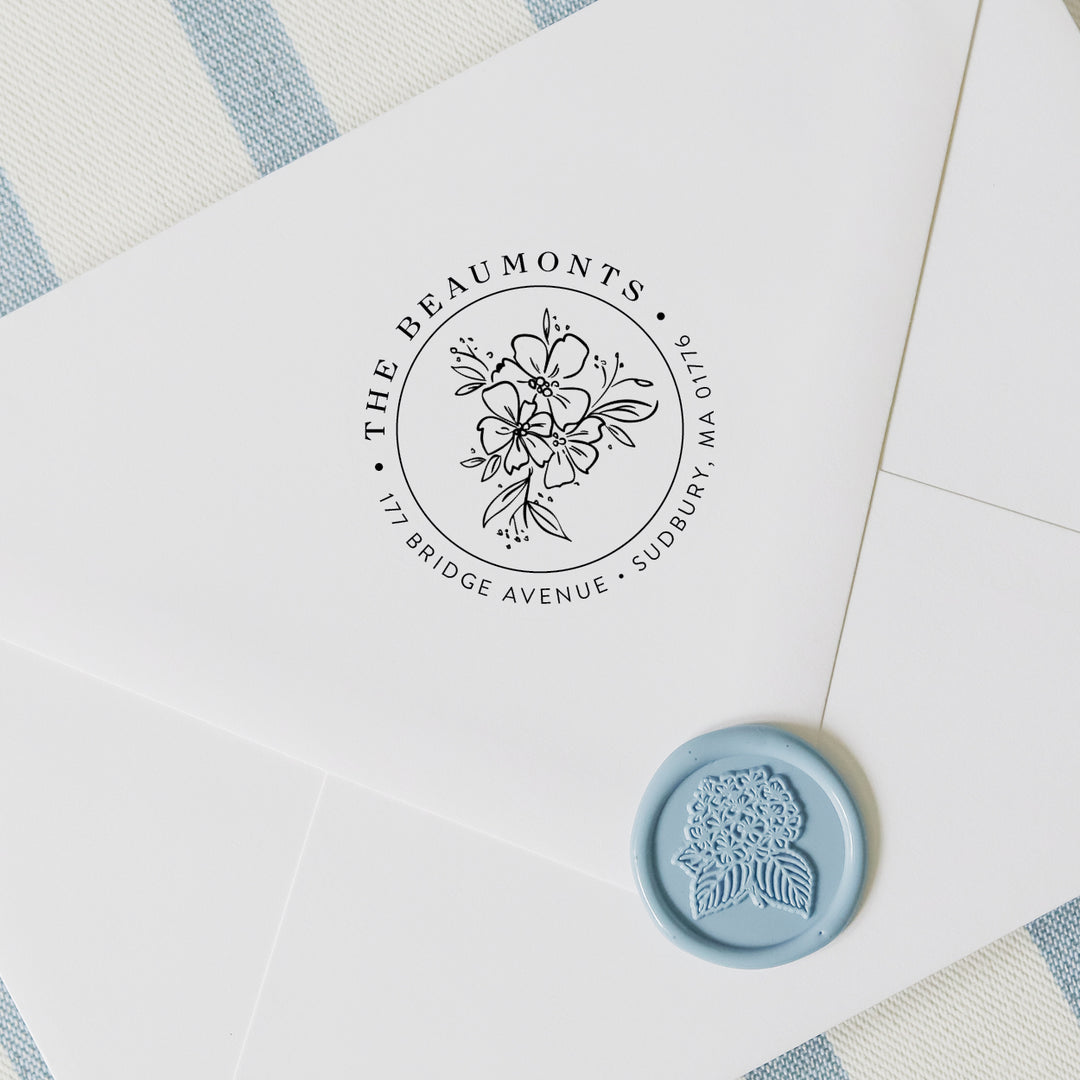 Personalized return address stamp in a wildflower design on a white envelope with hydrangea wax seal