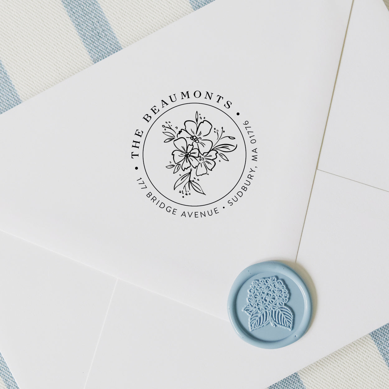 Personalized return address stamp in a wildflower design on a white envelope with hydrangea wax seal