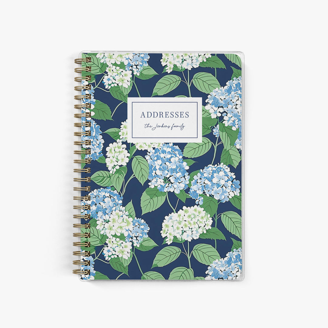 This custom address book features a preppy hydrangea pattern in blue and white with bright green leaves