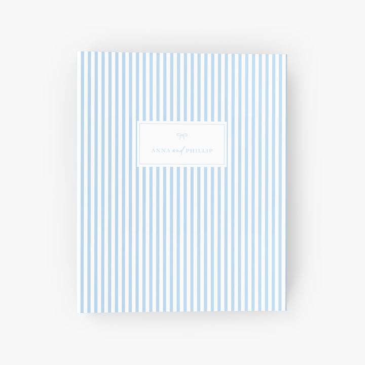 Personalized blue & white stripe wedding planning binder with the names of the bride and groom