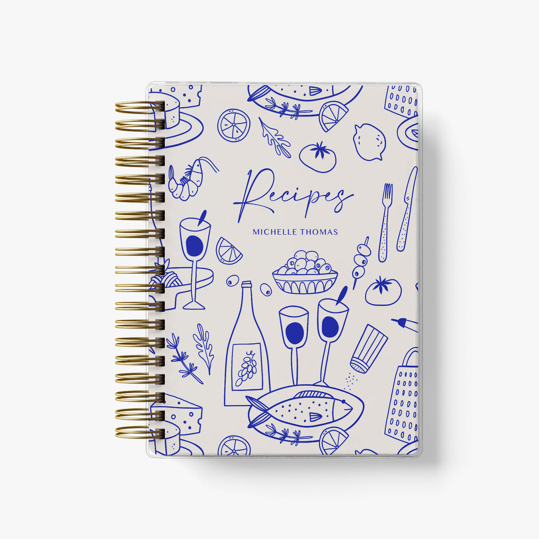 Custom recipe journal features a bold blue pattern of Mediterranean food personalized with your name