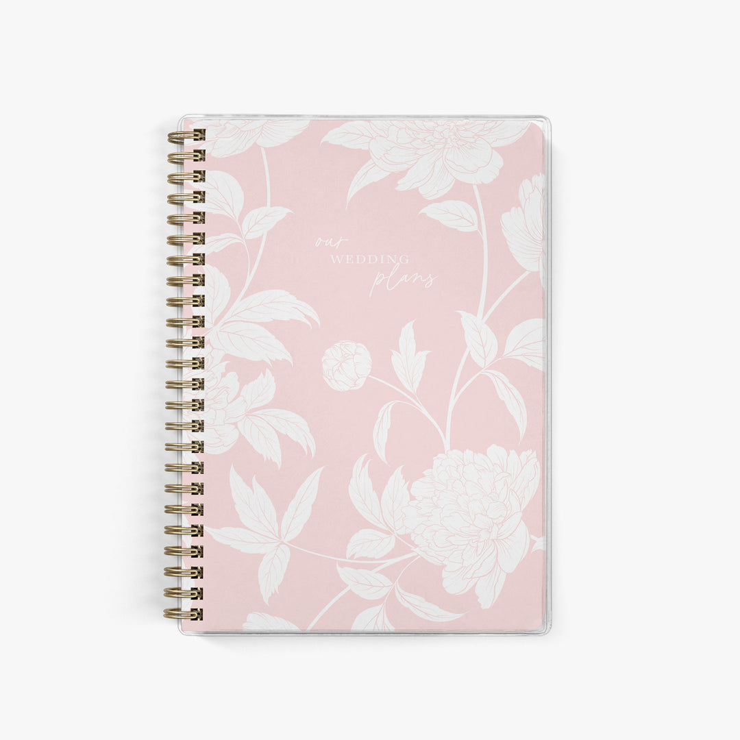Soft pink elopement planner with delicate white peony floral cover, ideal for romantic wedding planning and bridal gifts