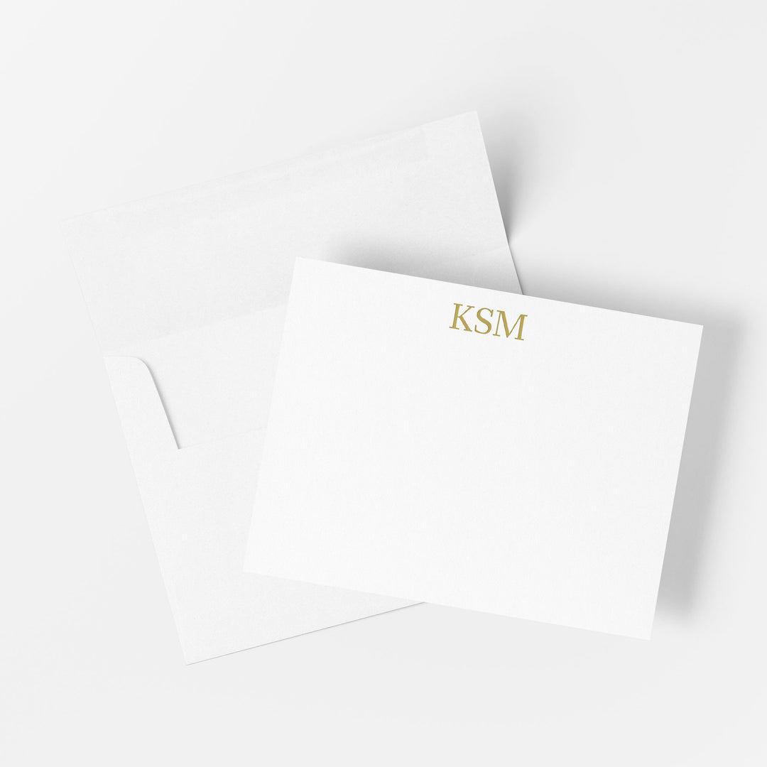 Monogrammed gold foil note card printed by hand on cotton paper with matching envelope on a white background