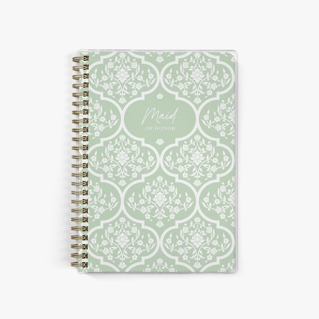 Our exclusive maid of honor planners are the perfect gift for your best friend, shown in a green & white floral trellis pattern.