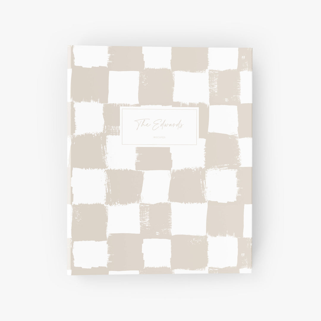 Custom recipe binder with a beige and white painted checkerboard pattern personalized with a family name